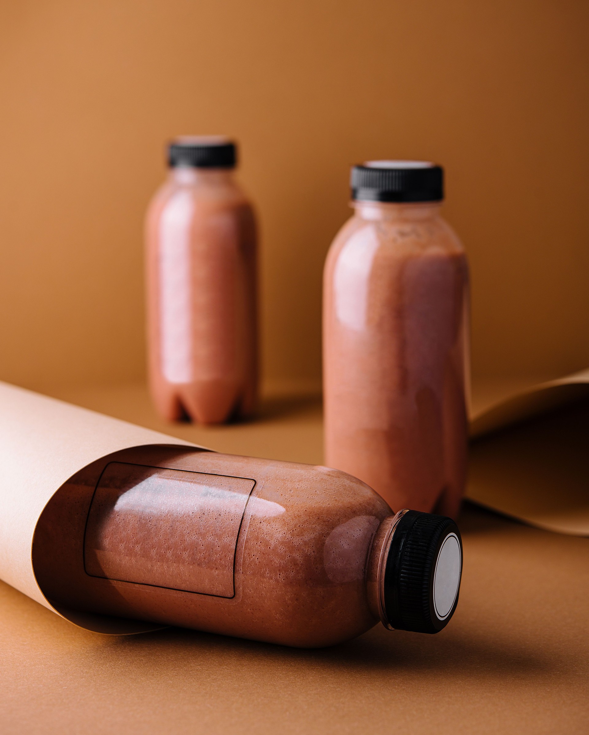 Chocolate protein shake in bottles with blank labels for mockup on brown background